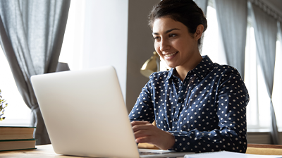 Panda7 Insurance A woman sitting at her desk while using her laptop