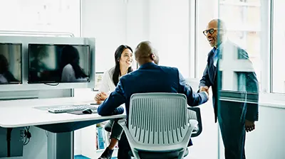 Rating Three colleagues in business attire conversing.