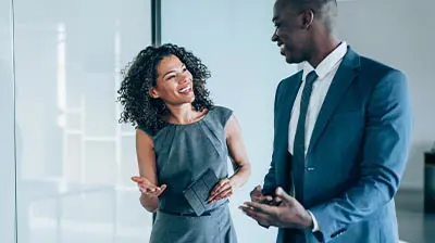 What Does Black Resistance Mean To Me? A man and a woman dressed in business attire, standing next to each other while having a discussion