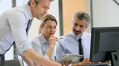 Applied Relay Auto Rec Two businessmen and a business woman working together on a computer and a tablet