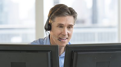 Applied Relay Broker Finance A man wearing a headset sitting at his computer