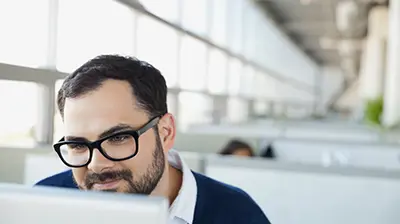 Why Being a Digital Agency Matters to Your Business Man smiling looking at computer monitor