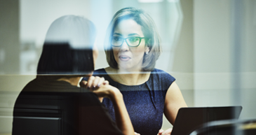 Integration Solutions Two women in casual attire both looking at each other.