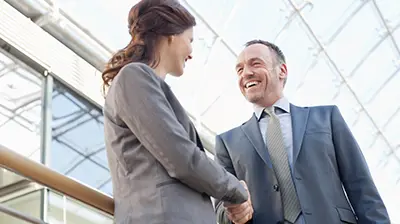 The 5 Benefits of Being a Digital Agency: Trust   A man and a woman, both wearing suits, shaking hands
