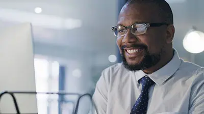 The Future of Commercial Insurance A business man smiling at his computer
