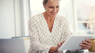 The Paperless Brokerage A woman smiling while using a smart tablet