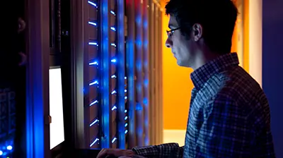 The Cloud and Data Security A man looking at a laptop in a server room